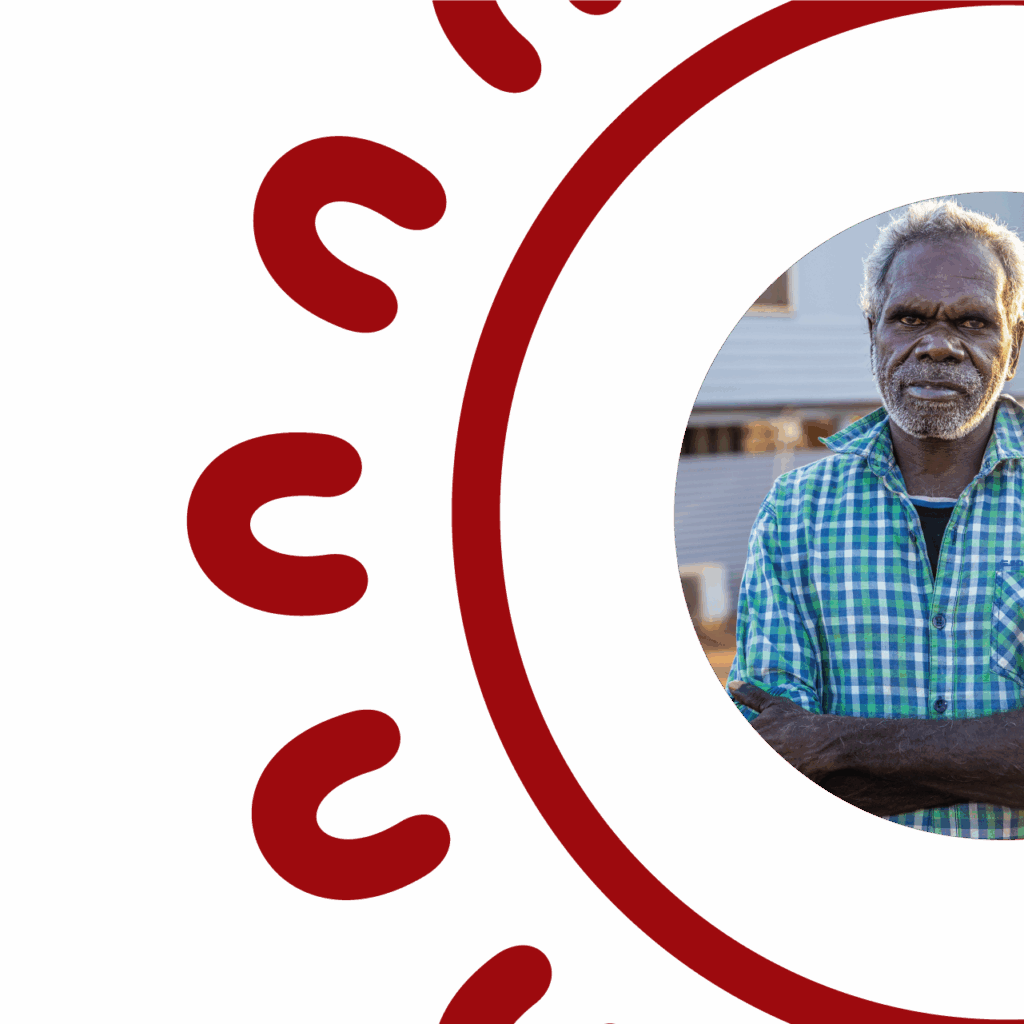 Circular portrait of an Aboriginal Elder with short grey hair and a white beard, arms crossed, wearing a green and white checked shirt, framed by the SCS Indigenous decorative red circular border featuring repeating U-shaped symbols inspired by Aboriginal art motifs, on a white background.
